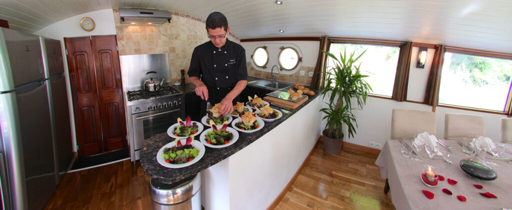 French Hotel Barge Enchante - Chef preparing lunch in demonstration galley