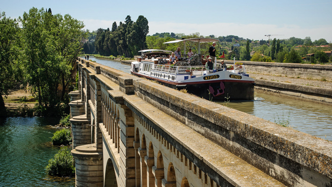 French Hotel Barge Athos crossing the river Orb via the pont-canal de l'Orb,