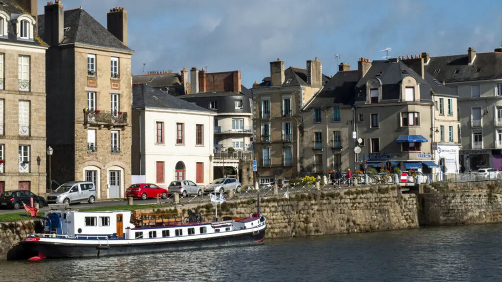 French Hotel Barge Nymphea moored along the town wall in Brittany France