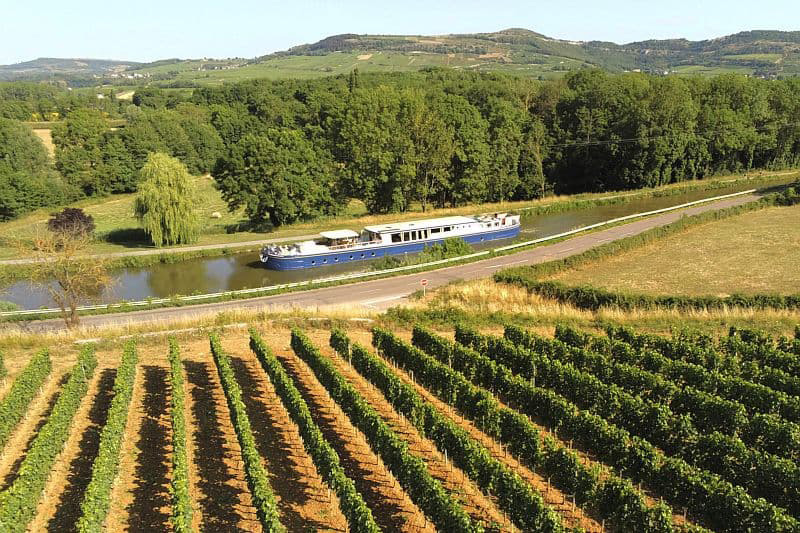 French Hotel Barge Finesse cruising past vineyards on the canal du midi France