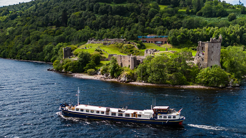 Scottish Hotel Barge Scottish Highlander cruising past Urquahart castle