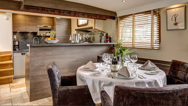 French Hotel Barge Rendez-Vous - This photo shows the Dining table with the Galley behind