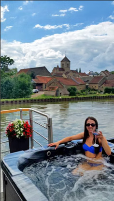 French Hotel Barge Rendez-Vous - Guest enjoying the hot tub with a beverage in hand