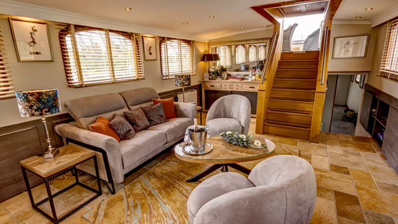 French Hotel Barge Rendez-Vous - This photo shows the Salon with sofas & chairs, Bar, Entrance stairway