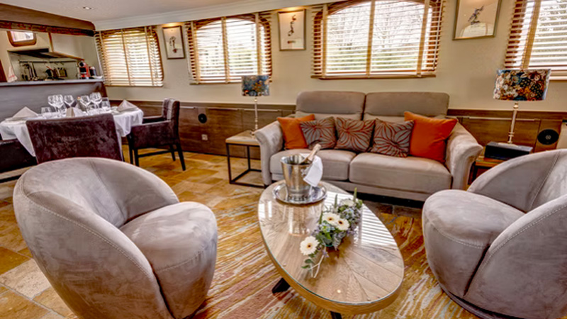 French Hotel Barge Rendez-Vous - This photo shows the Salon with sofas & chairs, Coffee table, Dining table